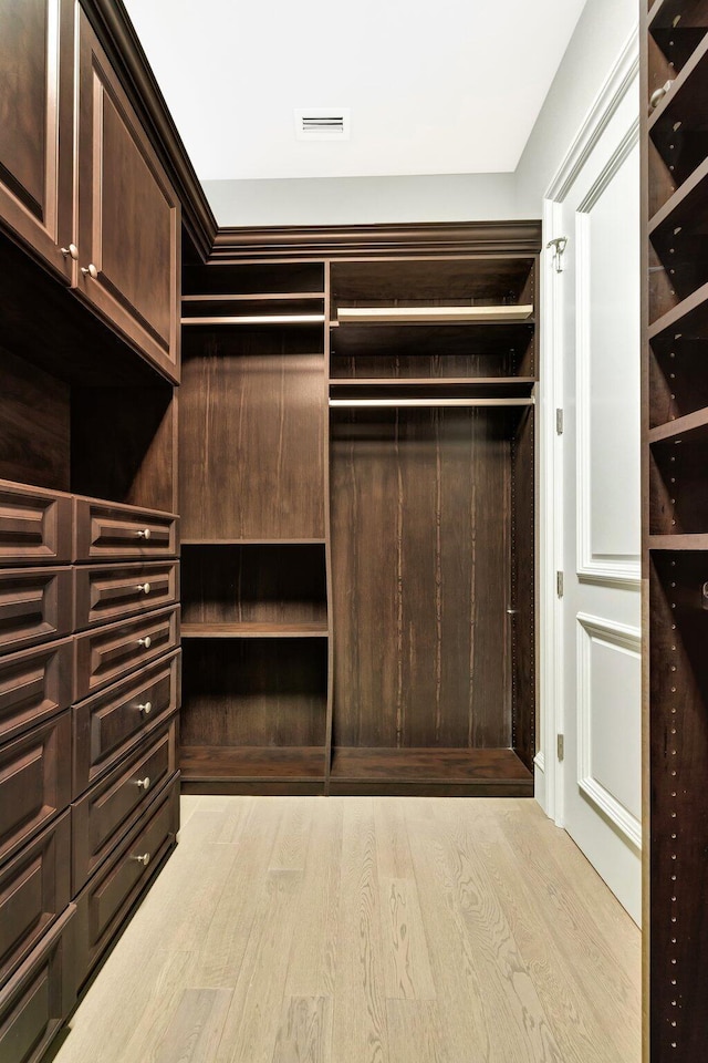 walk in closet with light wood finished floors and visible vents