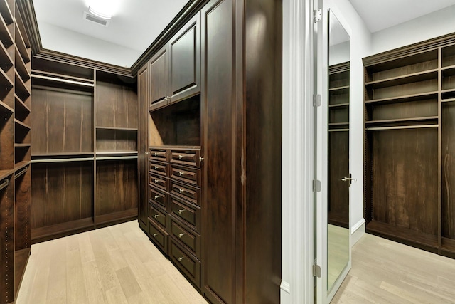 walk in closet with light wood-type flooring and visible vents