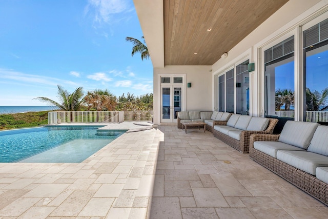 view of swimming pool with a water view, an outdoor living space, a fenced in pool, and a patio