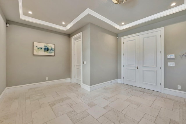 empty room featuring ornamental molding, baseboards, a raised ceiling, and recessed lighting