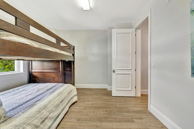 bedroom with baseboards and wood finished floors