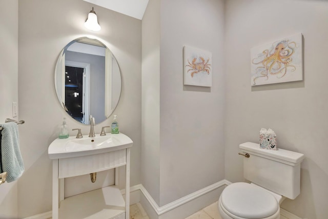 bathroom with toilet and baseboards