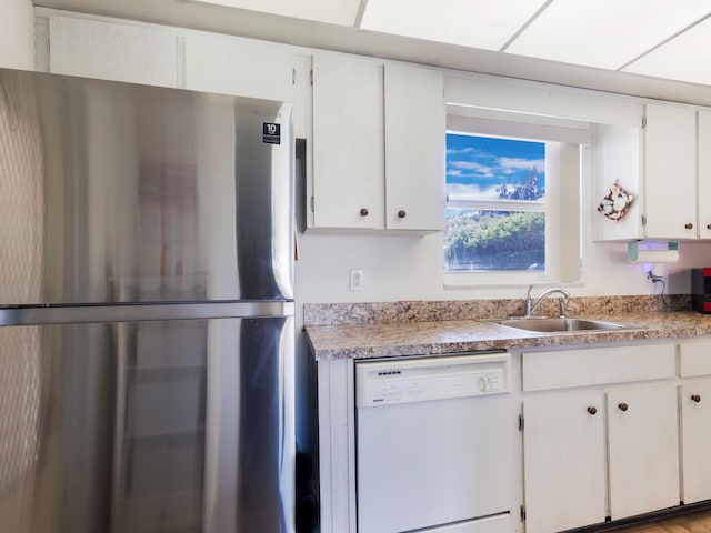 kitchen featuring white cabinets, stainless steel fridge, sink, and white dishwasher