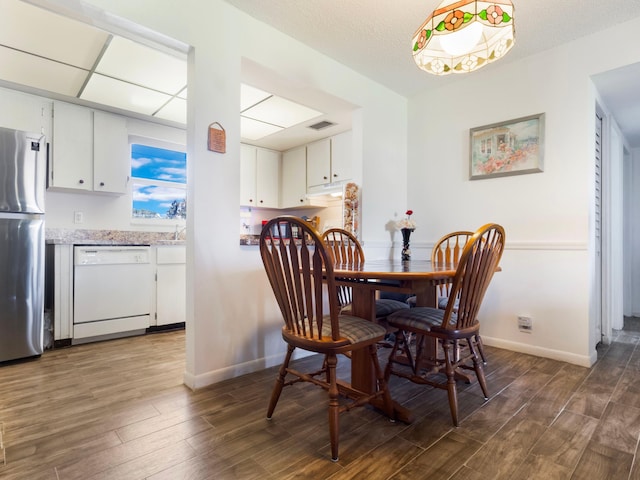 dining area with dark hardwood / wood-style floors and a textured ceiling