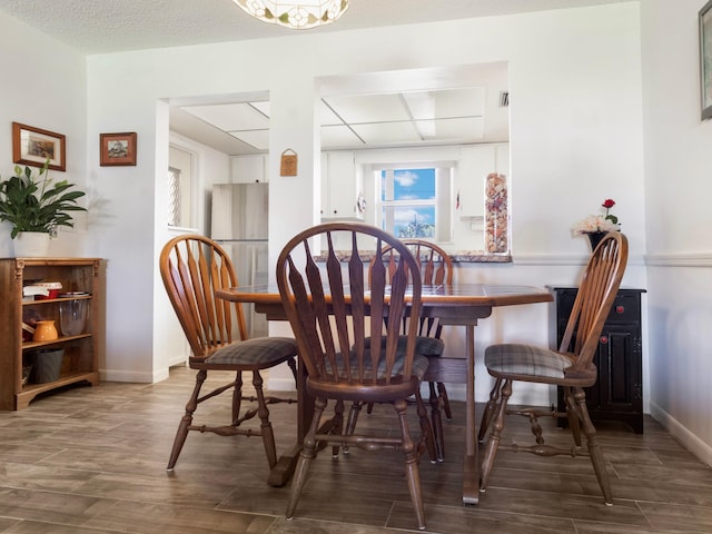 dining area with hardwood / wood-style floors and a textured ceiling