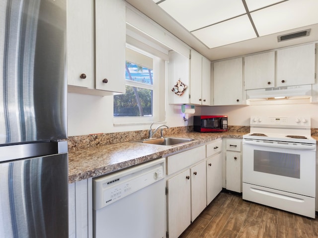 kitchen with white cabinetry, sink, dark wood-type flooring, and white appliances