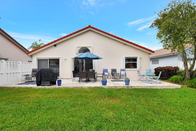 back of house with a patio area and a lawn