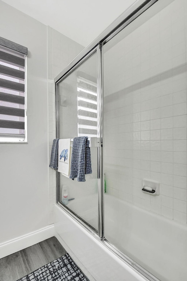 bathroom featuring hardwood / wood-style floors and enclosed tub / shower combo