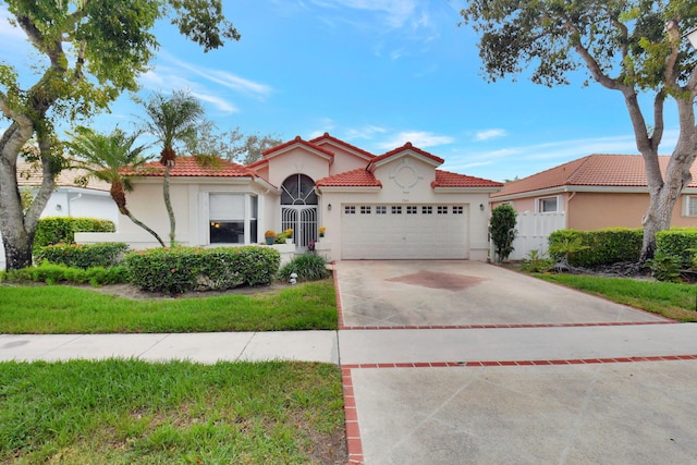 mediterranean / spanish-style home featuring a front yard and a garage