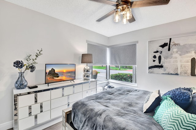 bedroom with ceiling fan and a textured ceiling