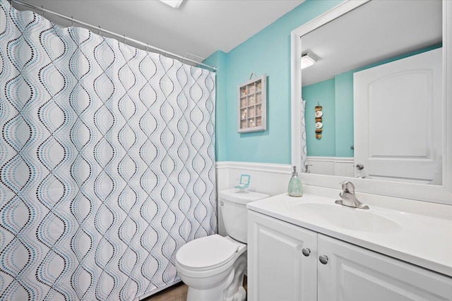 bathroom featuring walk in shower, vanity, and toilet