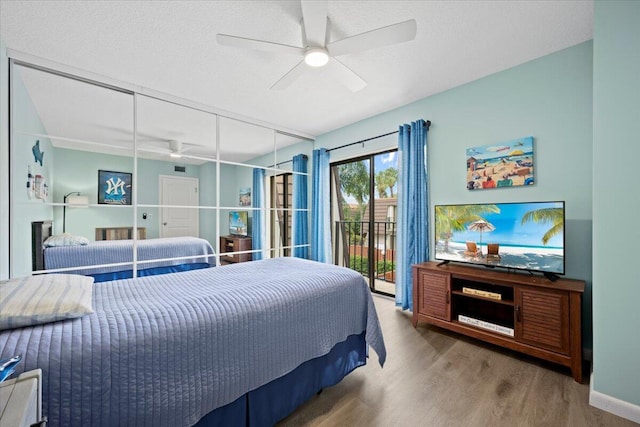 bedroom with ceiling fan, hardwood / wood-style flooring, access to outside, and a textured ceiling