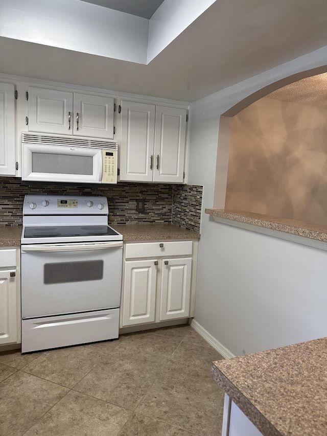 kitchen with backsplash, white appliances, and white cabinets