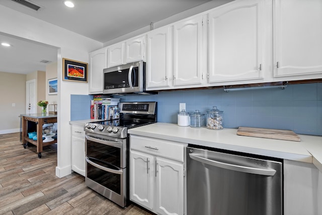 4316 S Ocean Blvd Unit 2S, Highland Beach, FL 33487 - kitchen with appliances with stainless steel finishes, tasteful backsplash, white cabinets, light wood finished floors, and light countertops