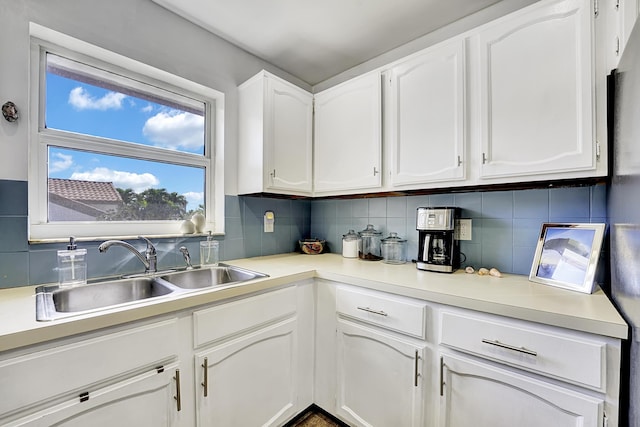 kitchen with white cabinetry, sink, and backsplash