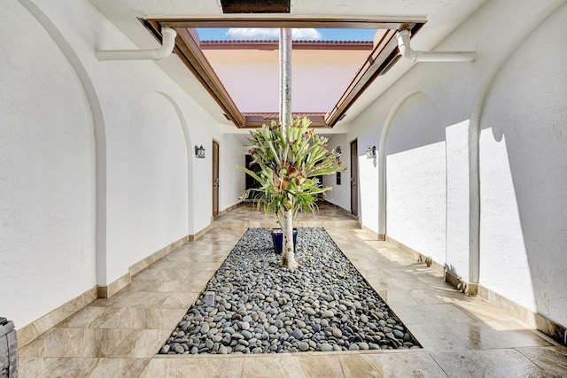 exterior space with arched walkways and stucco siding