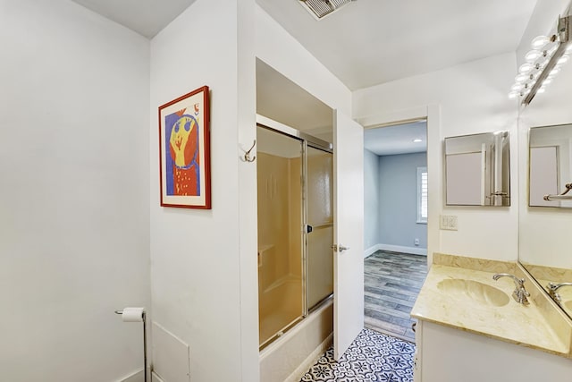 bathroom with vanity and combined bath / shower with glass door