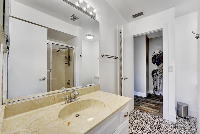 bathroom featuring walk in shower and vanity