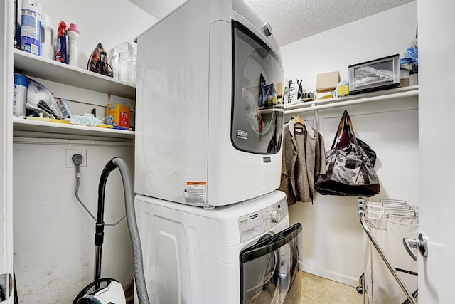 clothes washing area featuring stacked washing maching and dryer and a textured ceiling