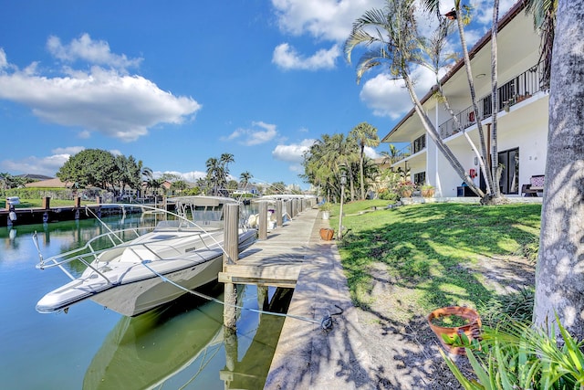 view of dock featuring a lawn and a water view