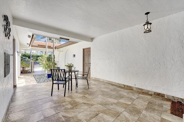 dining space featuring beam ceiling and a textured ceiling