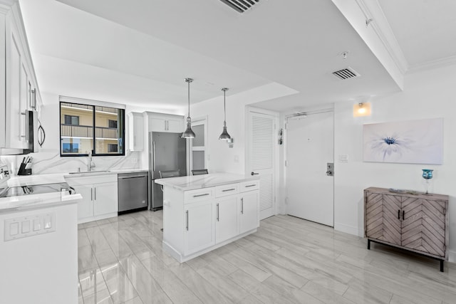 kitchen with a sink, hanging light fixtures, visible vents, appliances with stainless steel finishes, and white cabinetry