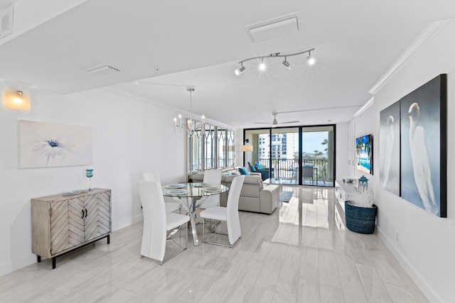 dining area with rail lighting, baseboards, a wall of windows, and crown molding