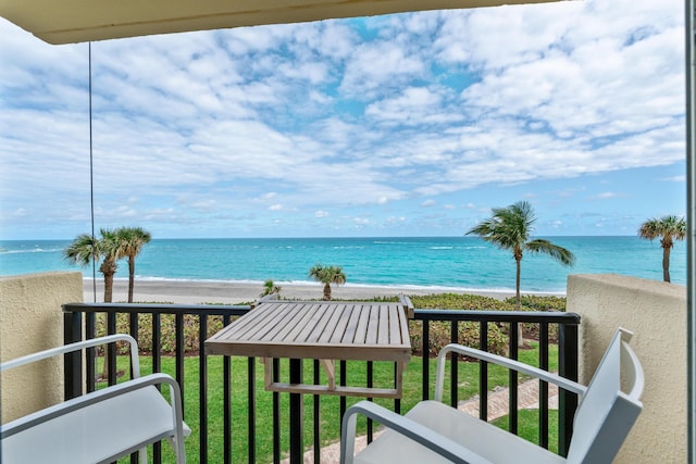 balcony featuring a beach view and a water view