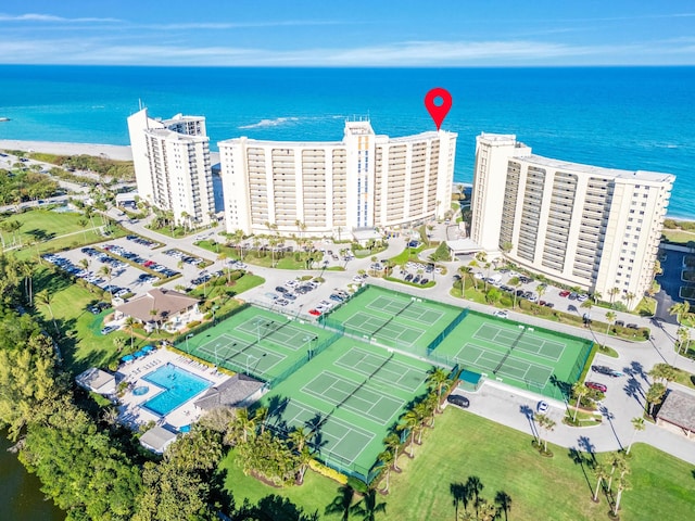 drone / aerial view featuring a view of city, a beach view, and a water view