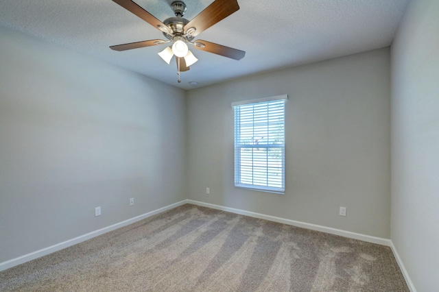 empty room with ceiling fan, light colored carpet, and a textured ceiling