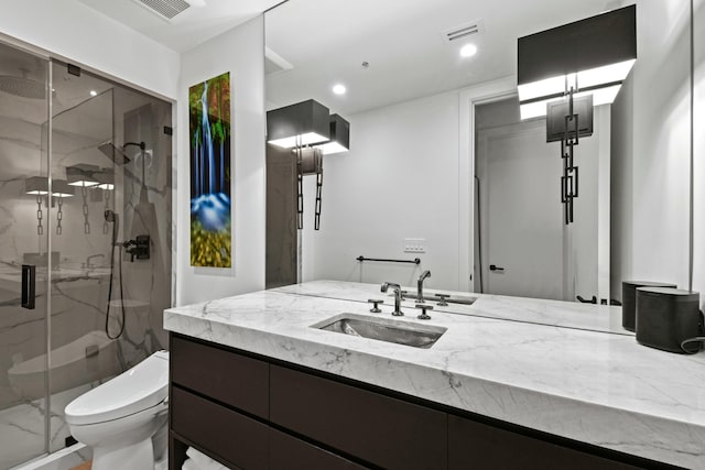 bathroom with vanity, a shower with shower door, and toilet