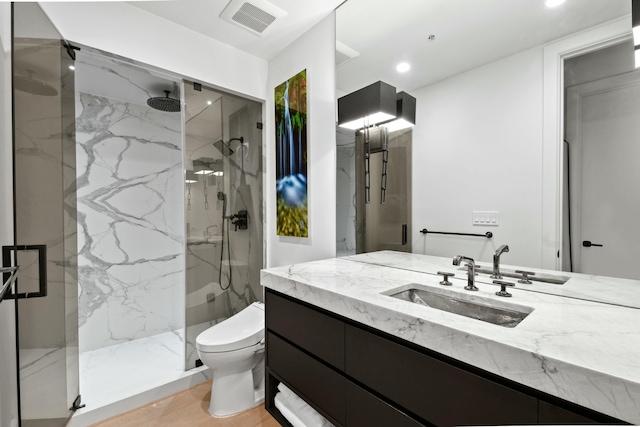 bathroom featuring walk in shower, vanity, and toilet