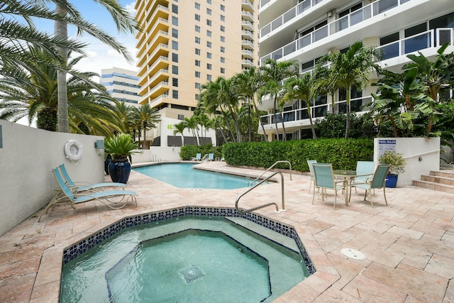 view of swimming pool with a patio area and a hot tub