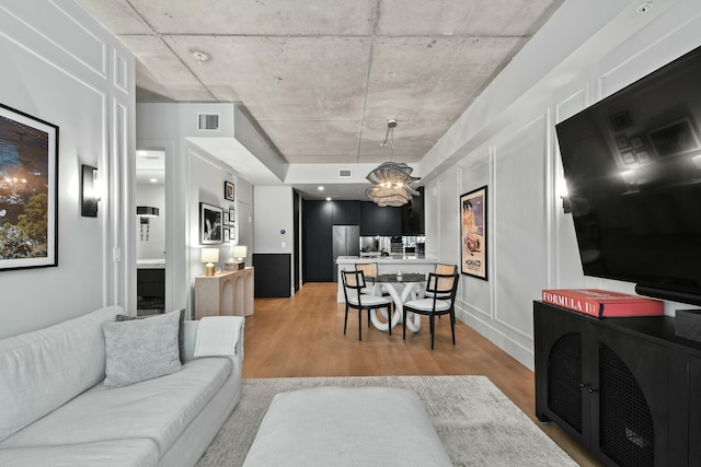 living room featuring an inviting chandelier and hardwood / wood-style floors