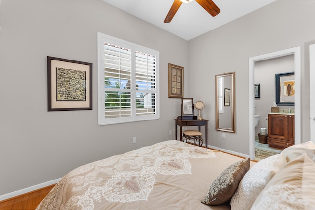 bedroom with hardwood / wood-style flooring, ensuite bathroom, and ceiling fan