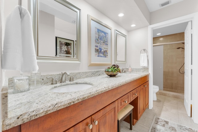 bathroom with tile patterned flooring, vanity, an enclosed shower, and toilet