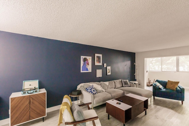 living room featuring a textured ceiling and light wood-type flooring