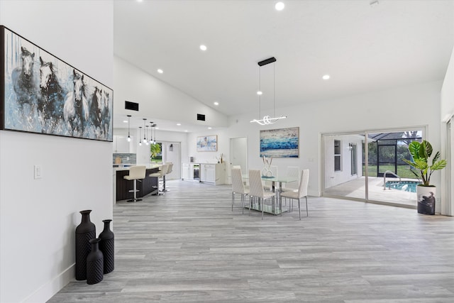 living room with light hardwood / wood-style flooring, high vaulted ceiling, and beverage cooler