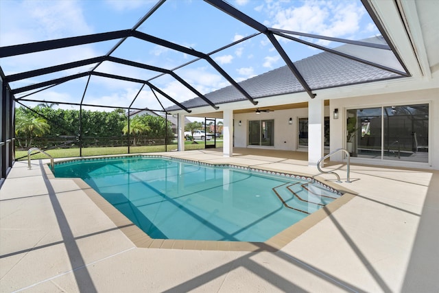 view of swimming pool featuring a patio, ceiling fan, and glass enclosure