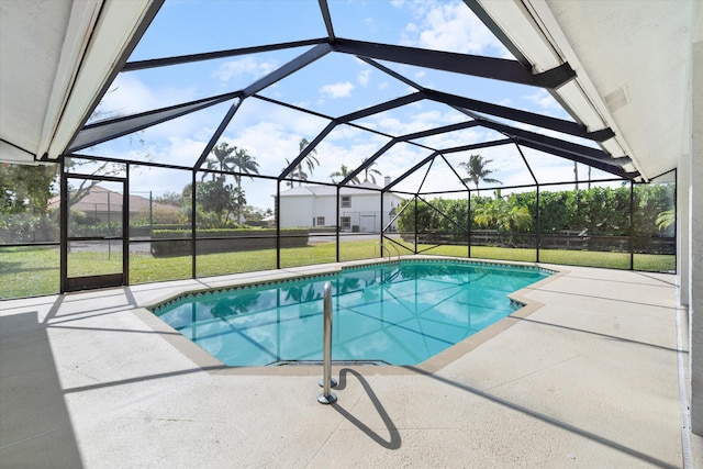 view of swimming pool featuring a patio, glass enclosure, and a lawn