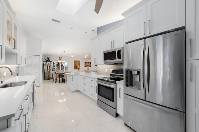 kitchen with white cabinetry, sink, decorative light fixtures, and appliances with stainless steel finishes