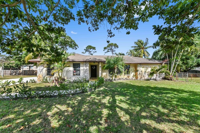 ranch-style house featuring fence, a front lawn, and stucco siding
