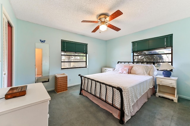 bedroom featuring dark carpet, a ceiling fan, and a textured ceiling