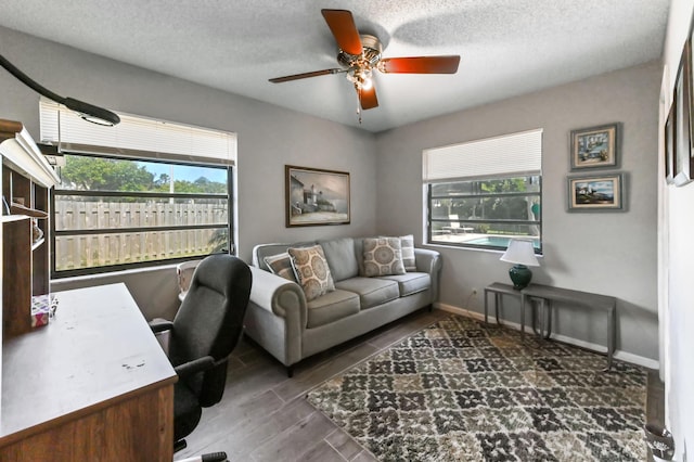 office area with ceiling fan, baseboards, a textured ceiling, and plenty of natural light