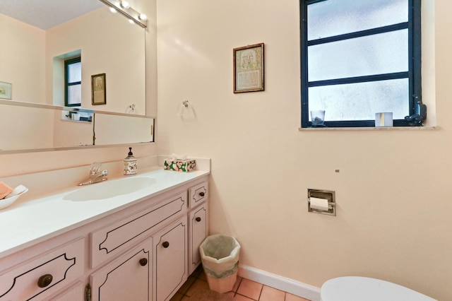 bathroom featuring vanity, toilet, tile patterned flooring, and baseboards