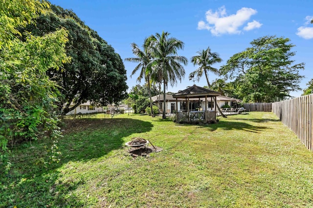 view of yard featuring a fenced backyard, an outdoor fire pit, and a gazebo