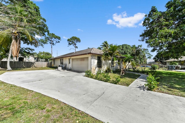 single story home featuring fence, a front lawn, stucco siding, an attached garage, and concrete driveway