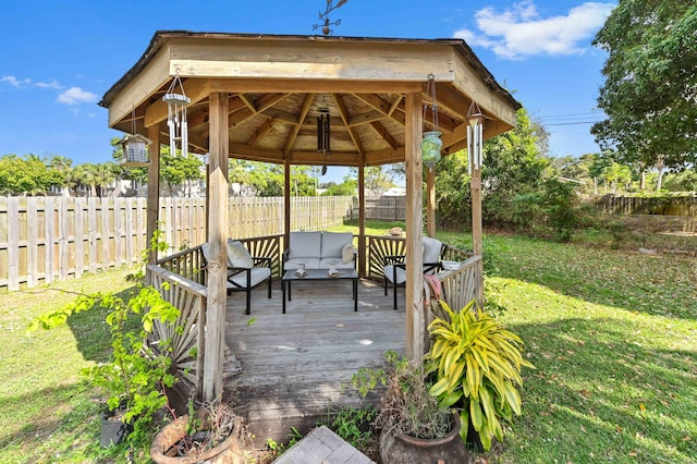 deck featuring a lawn, a gazebo, an outdoor living space, and a fenced backyard
