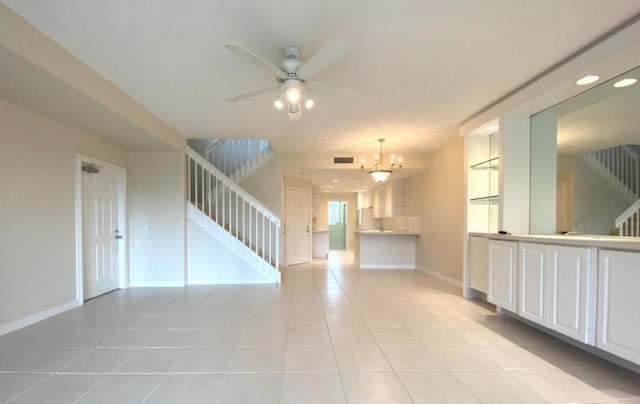 unfurnished room featuring light tile patterned floors and ceiling fan with notable chandelier