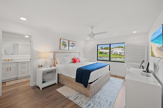 bedroom with dark wood-type flooring, ceiling fan, sink, and ensuite bath